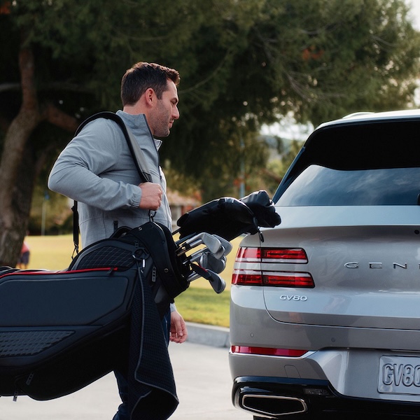 A golfer ready for a drive on the GV80