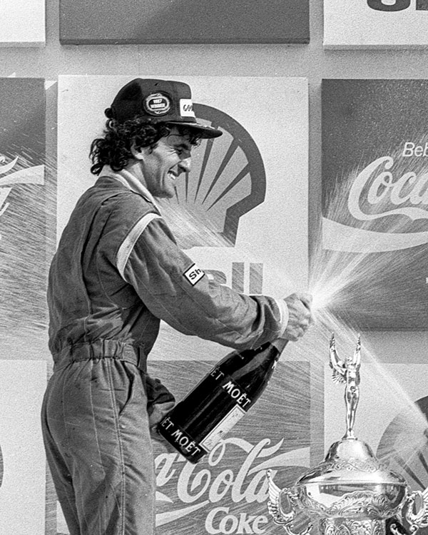 Le champion du monde de Formule 1 Alain Prost célébrant avec une bouteille de Moët & Chandon