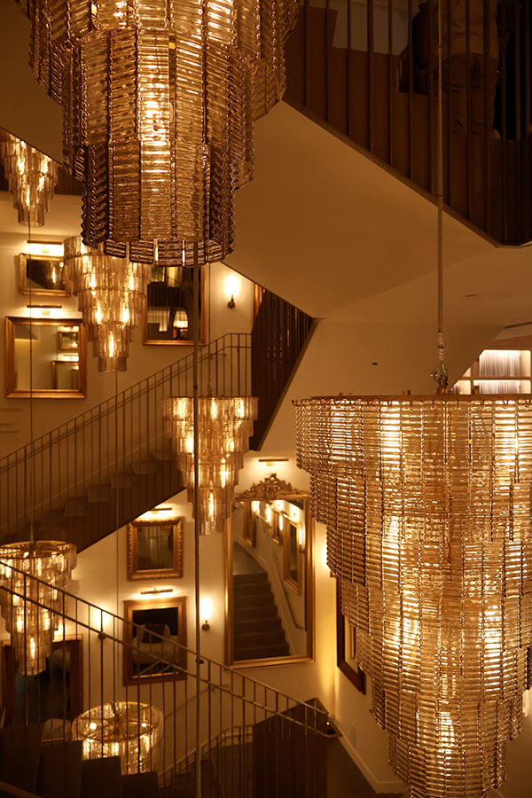 The impressive staircase at RH Montréal and its multiple light fixtures