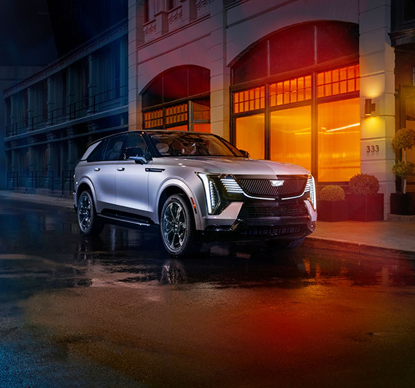 Front view of 2025 Cadillac Escalade IQ in Flare Metallic at night