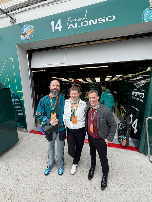 In the Aston Martin F1 garage with Mr. Justin Mastine-Frost, Mrs. Jamie Johnson, and driver Fernando Alonso (seated in his car)