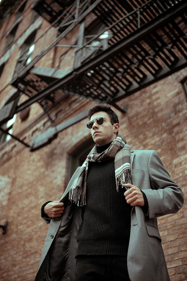 Man in a casual look with a long coat and a scarf